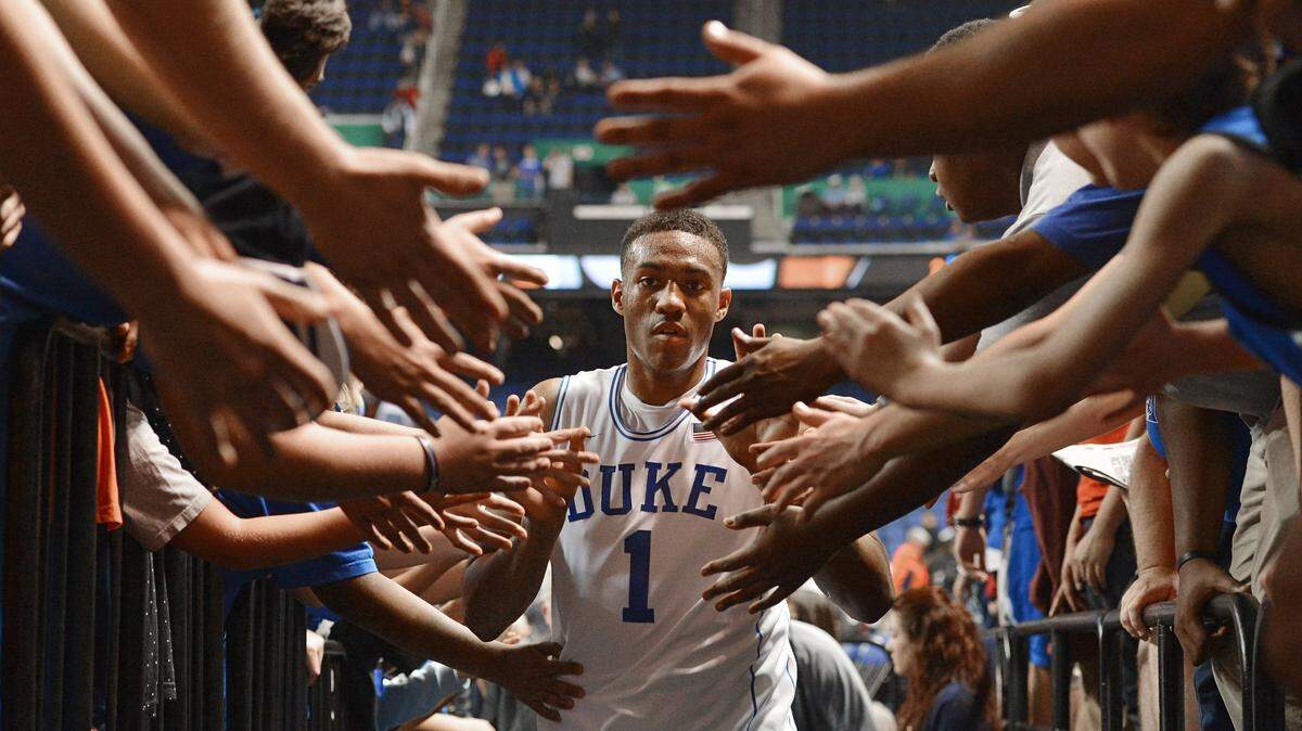 Duke forward Jabari Parker (1) walks through a phalanx of arms and hands as he heads to the locker room after the Blue Devils eliminated the Wolfpack. Duke advanced to face Virginia in the championship game of the ACC Men's Basketball Tournament defeating N.C. State 75-67 in Greensboro, N.C. Saturday, March 15, 2014.
