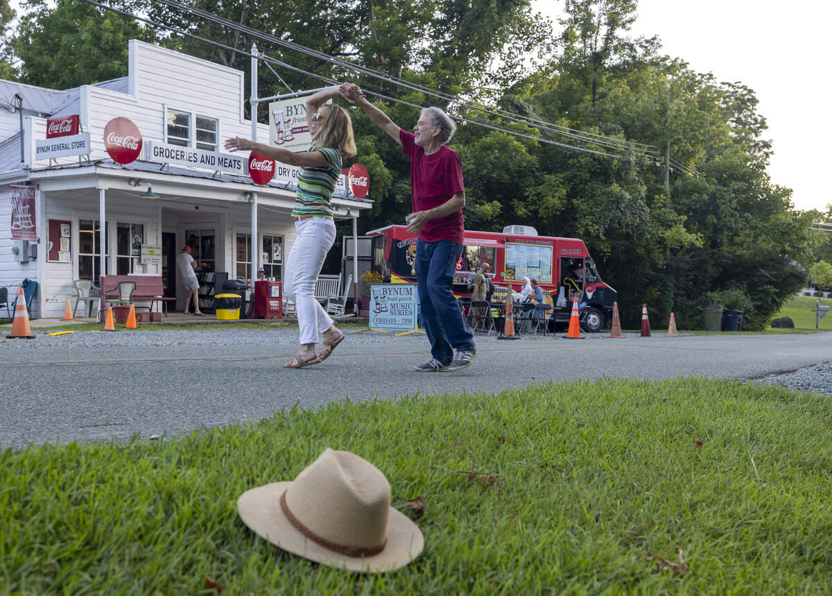 Bob Proctor and Braxton Malan dance to the music of the Durham Ukulele Orchestra during the Bynum Front Porch music series on Friday, July 11, 2025 in Bynum, N.C. 