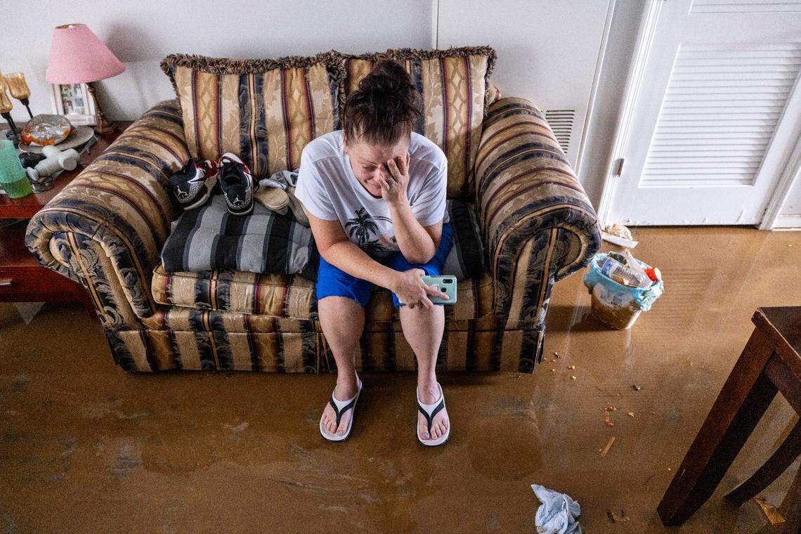 Jennifer Lyles, 46, is overwhelmed as she sits in the living room of her Rippling Streams Townhome in the Old Farm neighborhood along the Eno River in Durham on Monday morning, July 7, 2025, after flash flooding caused by Tropical Storm Chantal. Lyles said she was awakened by firefighters in a boat around 2:30 a.m.