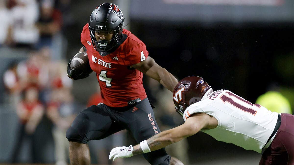 N.C. State running back Jayden Scott (4) escapes the pressure by Virginia Tech safety Tyson Flowers (11) during the first half of N.C. State’s game against Virginia Tech at Carter-Finley Stadium in Raleigh, N.C., Saturday, Sept. 27, 2025.