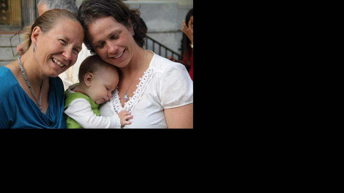 Janet White, 41, (left) and Hilary Sheaves, 34, with the couple's daughter Ellis, were legally married Monday at the Durham County Register of Deeds office in the old courthouse building on East Main Street. "People said go ahead and do it before they take it away," White says of being among the first on the first day same-sex marriages were allowed in Durham.
