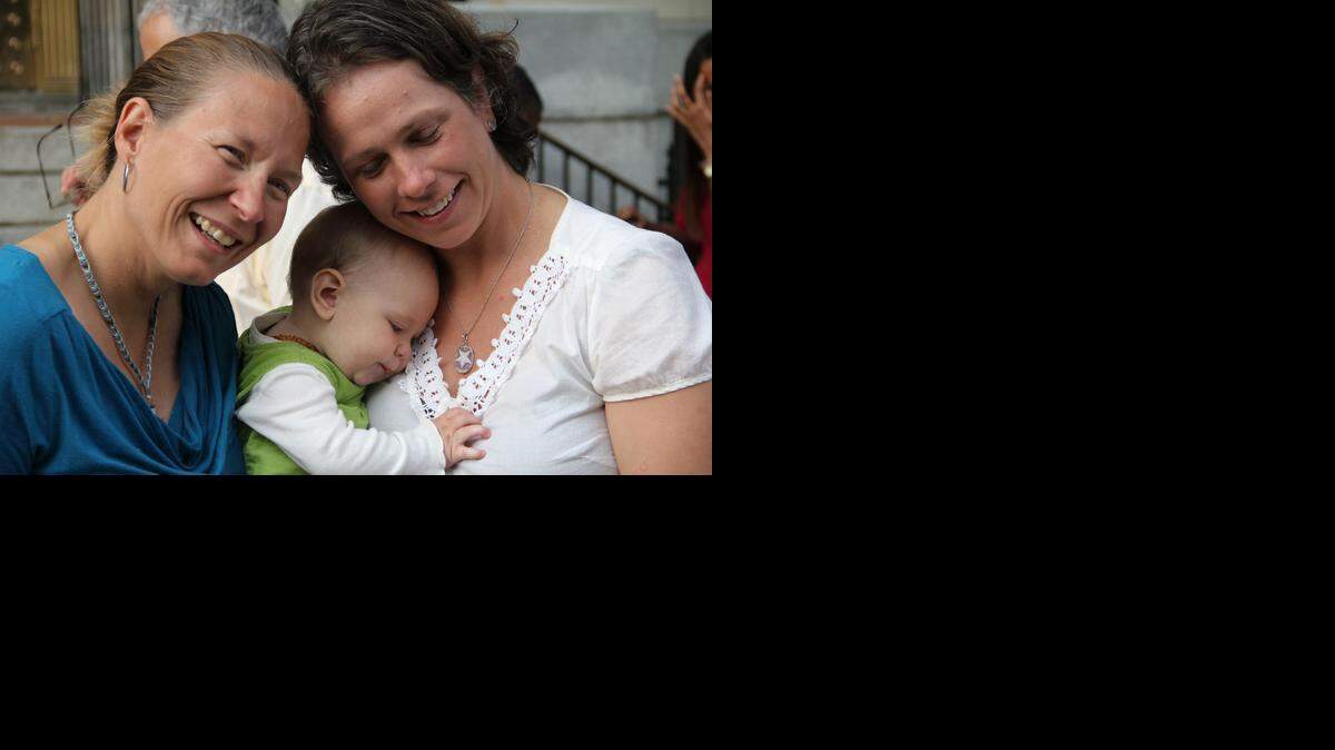 Janet White, 41, (left) and Hilary Sheaves, 34, with the couple's daughter Ellis, were legally married Monday at the Durham County Register of Deeds office in the old courthouse building on East Main Street. "People said go ahead and do it before they take it away," White says of being among the first on the first day same-sex marriages were allowed in Durham.
