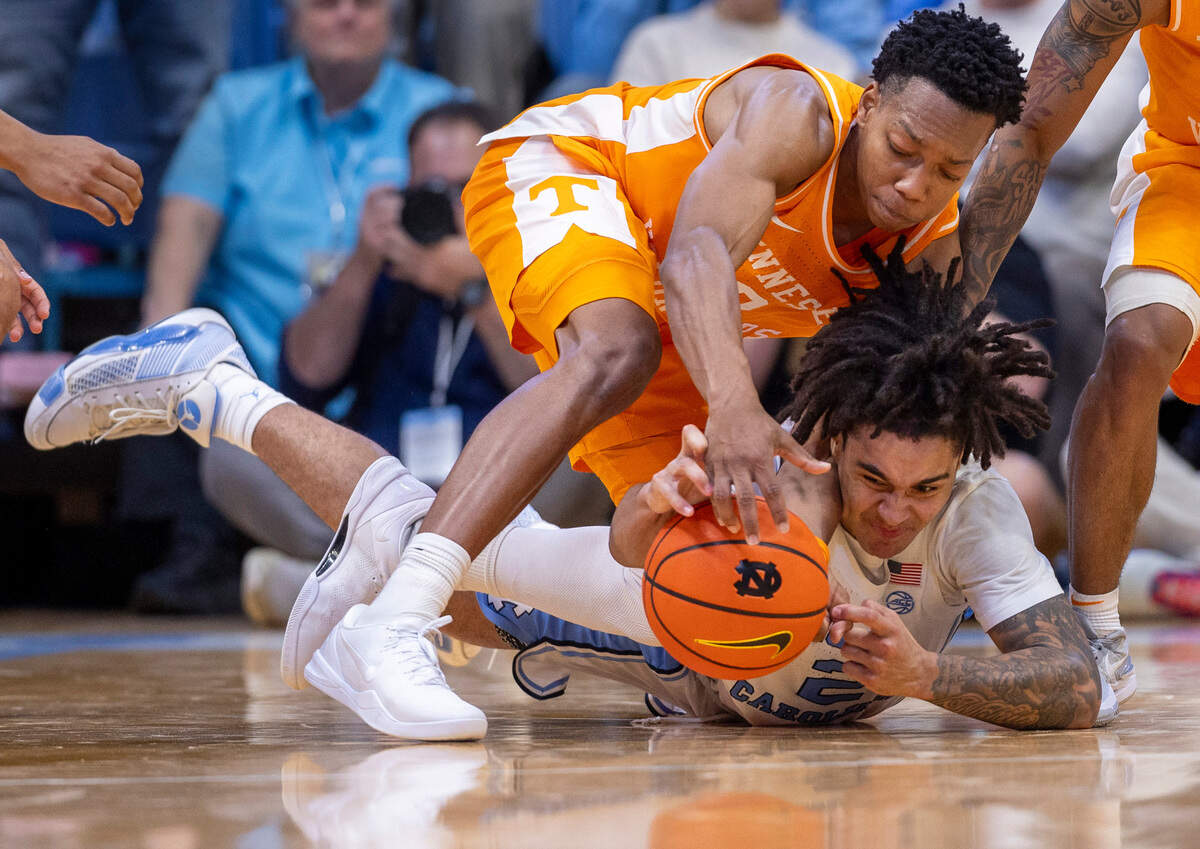 North Carolina’s Elliot Cadeau (2) and Tennessee’s Jonas Aidoo (0) dive to collect a loose ball in the final seconds of play on Wednesday, November 29, 2023 at the Smith Center in. Chapel Hill, N.C.