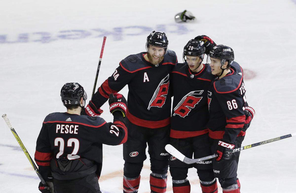 Carolina Hurricanes’ Sebastian Aho (20), of Finland, is congratulated by Brett Pesce (22), Jaccob Slavin (74) and Teuvo Teravainen (86), also of Finland, following Aho’s hat trick during the third period of an NHL hockey game against the Nashville Predators in Raleigh, N.C., Sunday, Jan. 13, 2019