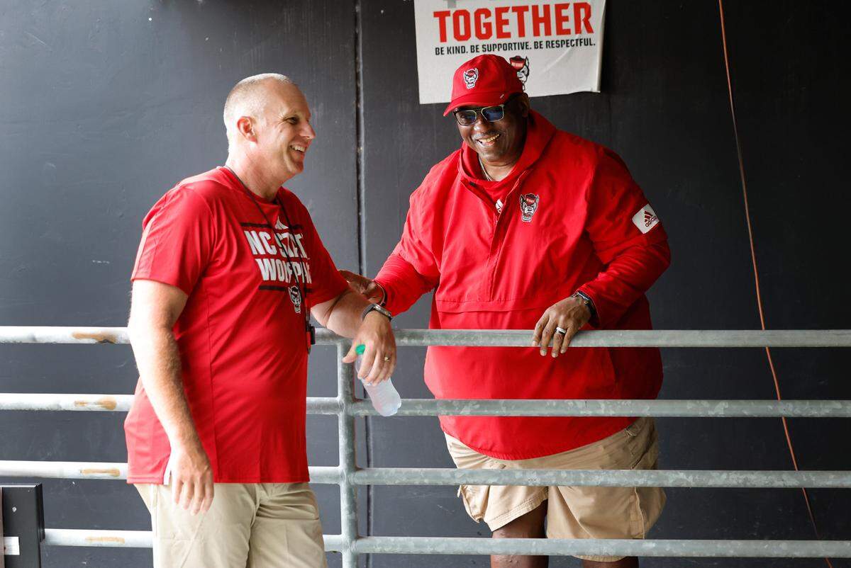 N.C. State head football coach Dave Doeren laughs with Ruffin McNeill, special assistant to the head coach, before the Wolfpack’s Victory Day at Carter-Finley Stadium in Raleigh, N.C., Friday, August 2, 2024.