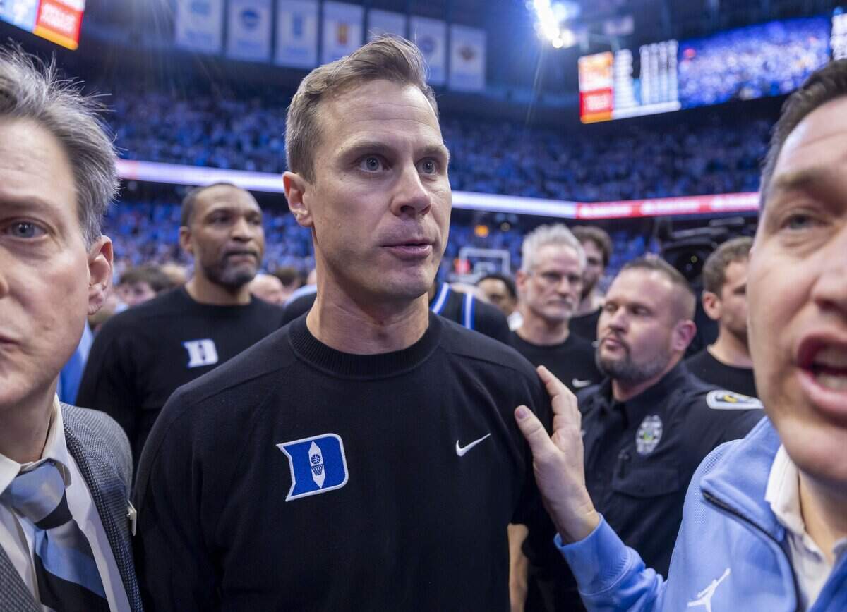 Duke coach Jon Scheyer and his players try to get off the Smith Center Court following a three-point shot by North Carolina guard Seth Trimble on Saturday, February 7, 2026 at the Smith Center in Chapel Hill, N.C.  Scheyer voiced his disappointment at not being able to get off the court safely at the end of the game once fans stormed the court. 