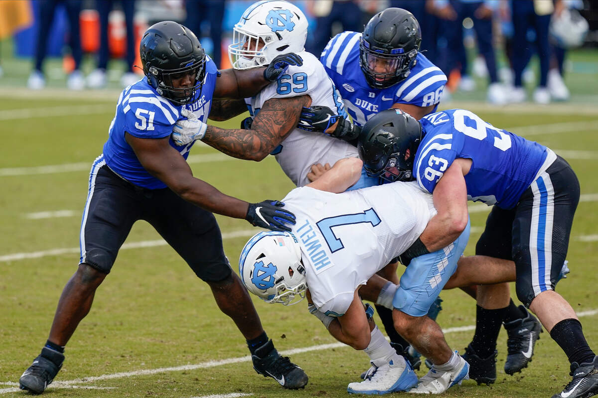 North Carolina Tar Heels quarterback Sam Howell (7) is sacked by Duke Blue Devils defensive end Victor Dimukeje (51) and defensive tackle Ben Frye (93) during the second half at Wallace Wade Stadium. 