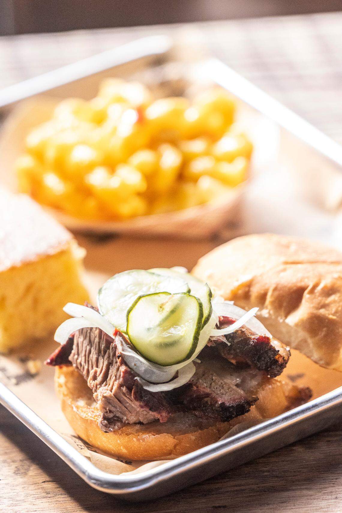 A brisket sandwich, pimento mac and cheese and cornbread sit on a tray during the opening of Longleaf Swine in Raleigh Friday, Nov. 4, 2022.