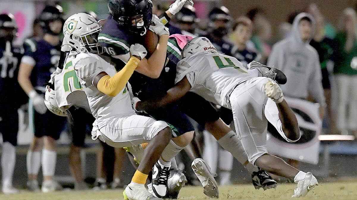 Leesville Road wide receiver Evan List (16) is tackled by Cardinal Gibbons’ Braylon Peebles (4) and Matthew Greene (7) during the first half. The Leesville Road Pride and the Cardinal Gibbons Crusaders met in a conference football game in Raleigh, N.C. on November 1, 2024.