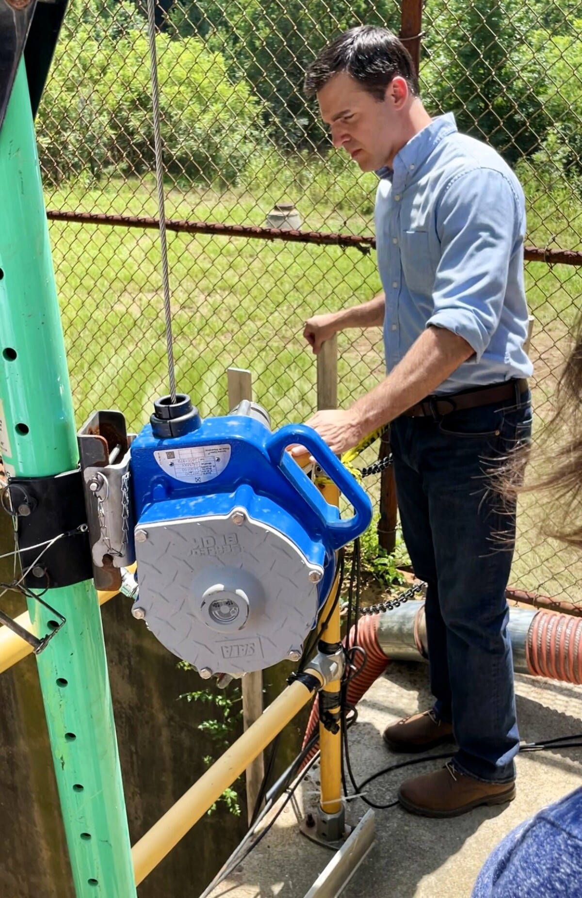 Attorney General Jeff Jackson looks over the railing into the raw sewage well at Hillsborough’s River Pump Station on Thursday, July 24, 2025. The well and the pump station flooded, dumping raw sewage into the Eno River on July 7, 2025.