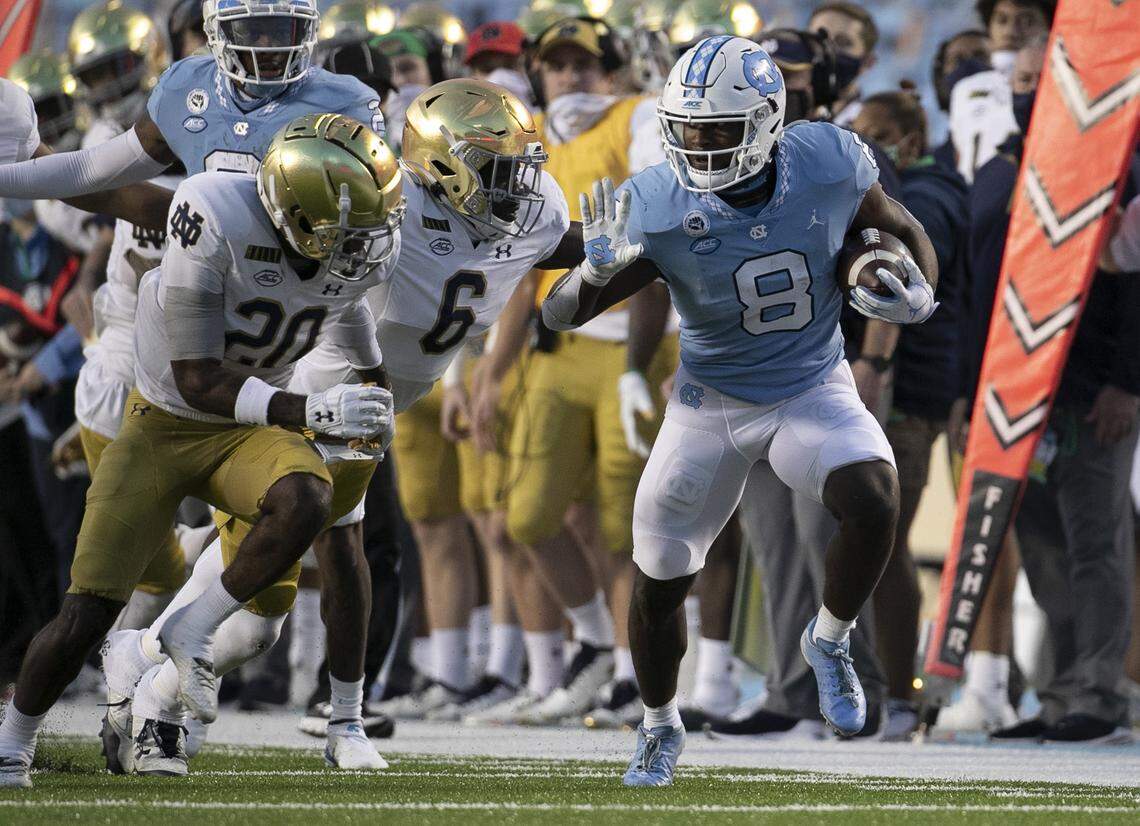 North Carolina’s Michael Carter (8) looks for running room against Notre Dame’s Jeremiah Owusu-Koramoah (6) in the second quarter on Friday, November 27, 2020 at Kenan Stadium in Chapel Hill, N.C.