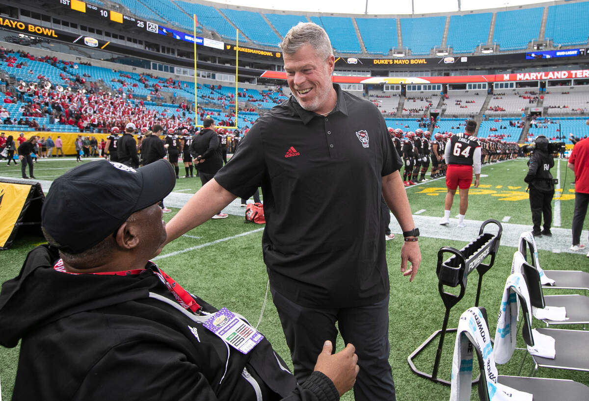 N.C. State offensive line coach Garett Tujague talks with special assistant to the head coach Ruffin McNeill before the Duke’s Mayo Bowl at Bank of America Stadium in Charlotte, N.C., Friday, Dec. 30, 2022. Tujague coached with McNeill at Virginia in 2016.