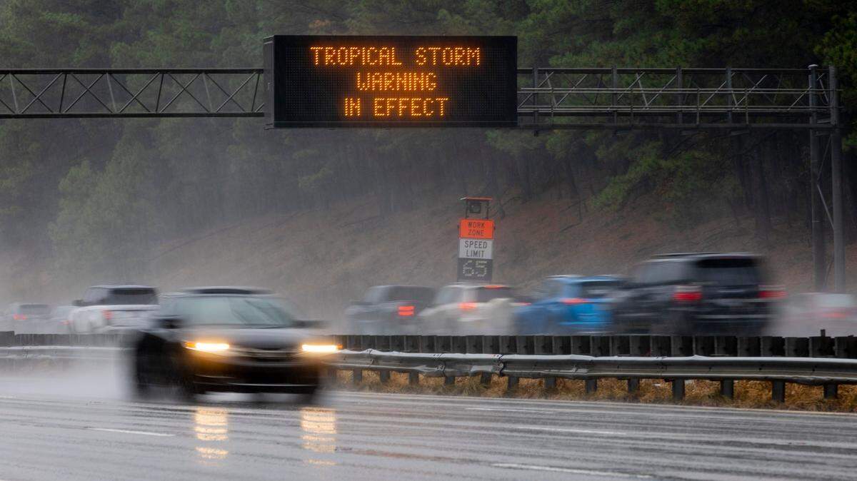 A North Carolina Department of Transportation sign along I-40 near RDU International Airport issues a Tropical Storm Warning, as remnants of Hurricane Ian move into the area on Friday morning, September 30, 2022 in Cary, N.C.