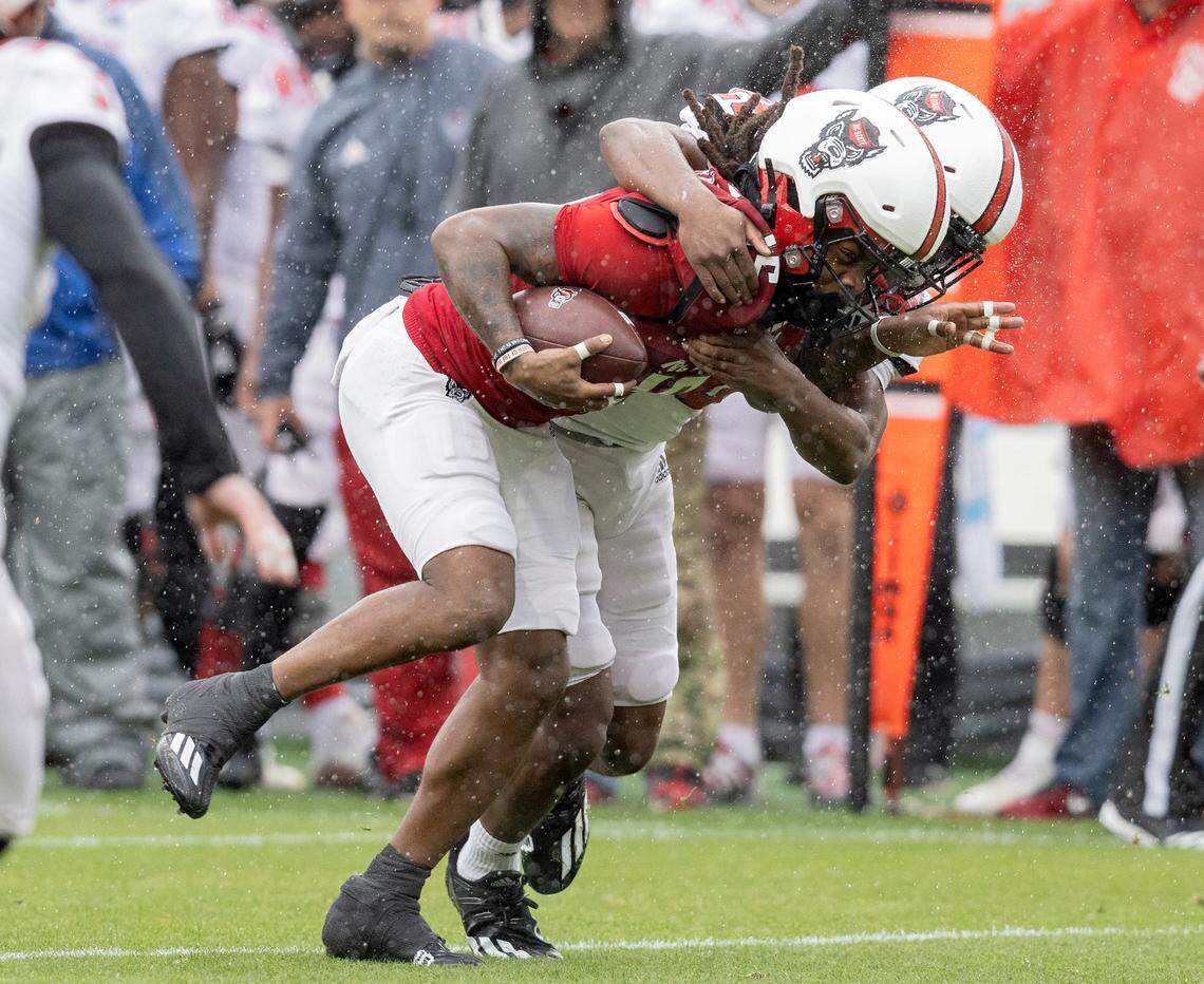 N.C. State’s Keyon Lesane carries the ball under pressure during the Wolfpack’s spring game at Carter-Finley Stadium on Saturday, April 8, 2023, in Raleigh, N.C.