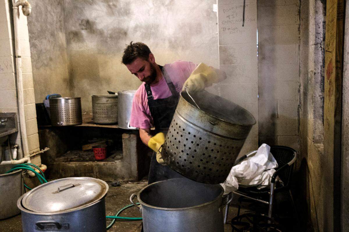 Tyler Howerton steams oysters at Bowen’s Island Restaurant during an oyster roast event near Charleston, S.C. Oct. 8, 2021.