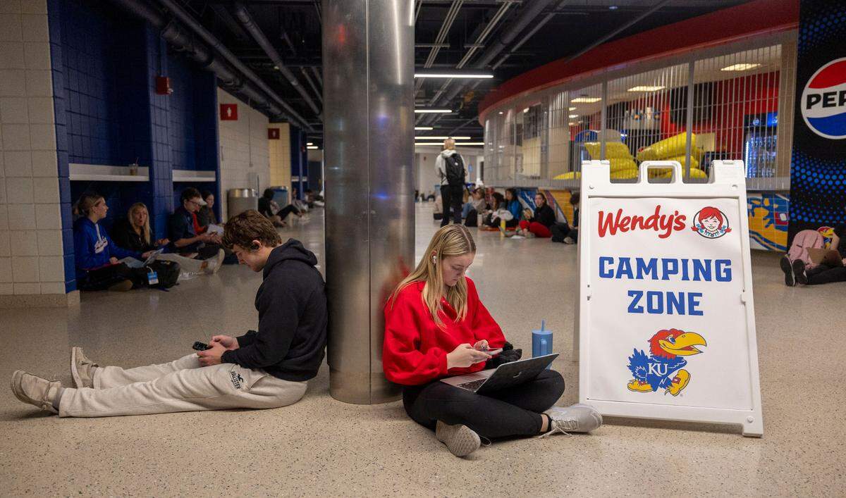 University of Kansas students Sam Marchand and Sophia Rossetti wait in the lobby with fellow students at Allen Fieldhouse for their tickets to the North Carolina vs Kansas game on Thursday, November 7, 2024 in Lawrence, Kansas.