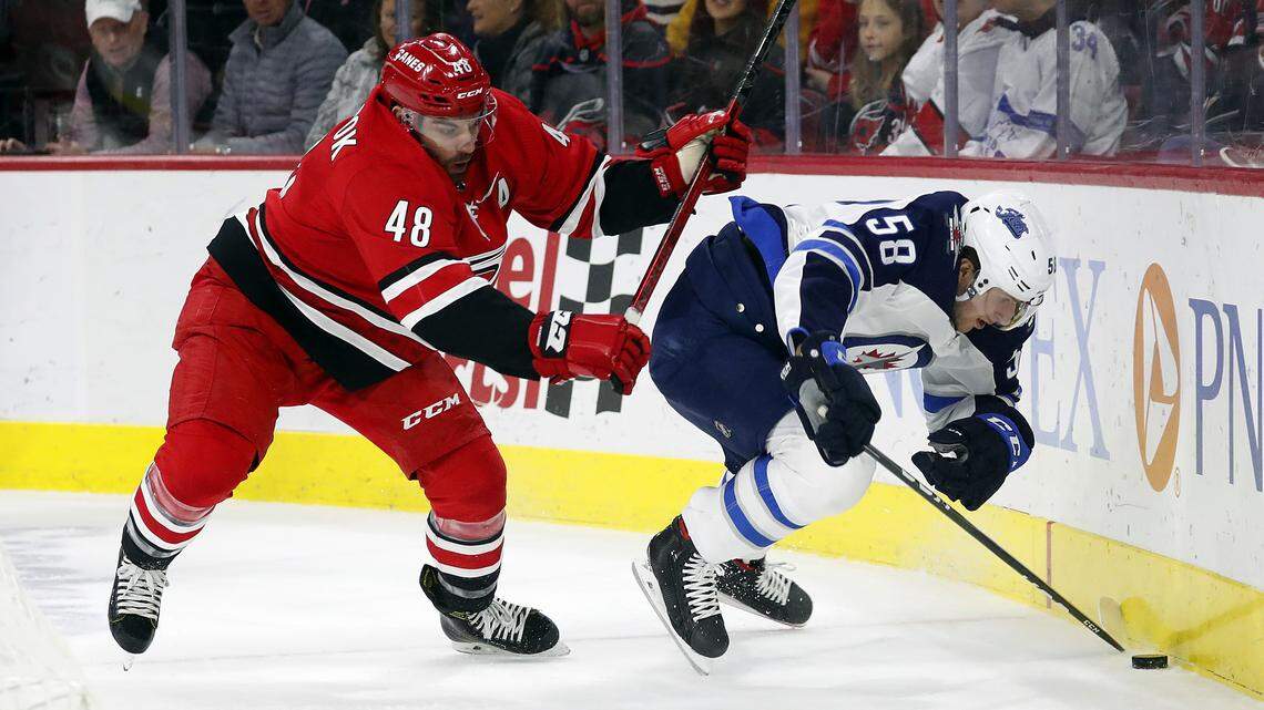 Carolina Hurricanes’ Jordan Martinook (48) battles with Winnipeg Jets’ Jansen Harkins (58) for the puck during the first period of an NHL hockey game in Raleigh, N.C., Tuesday, Jan. 21, 2020. (AP Photo/Karl B DeBlaker)
