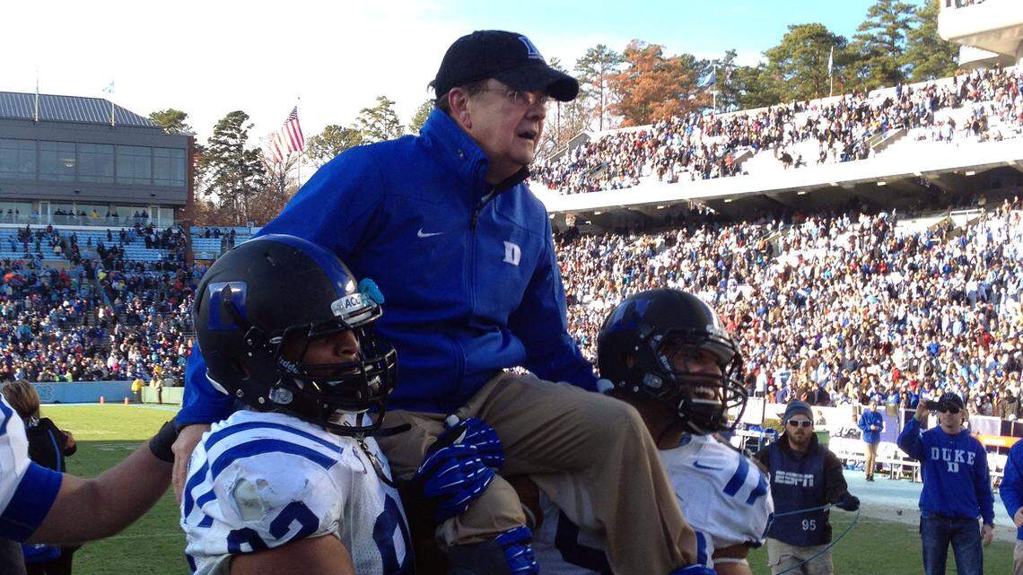 Duke coach David Cutcliffe gets carried off the field by Sydney Sarmiento and Justin Foxx after the Blue Devils’ 27-25 win over UNC at Kenan Stadium in Chapel Hill on Saturday, Nov. 30, 2013.