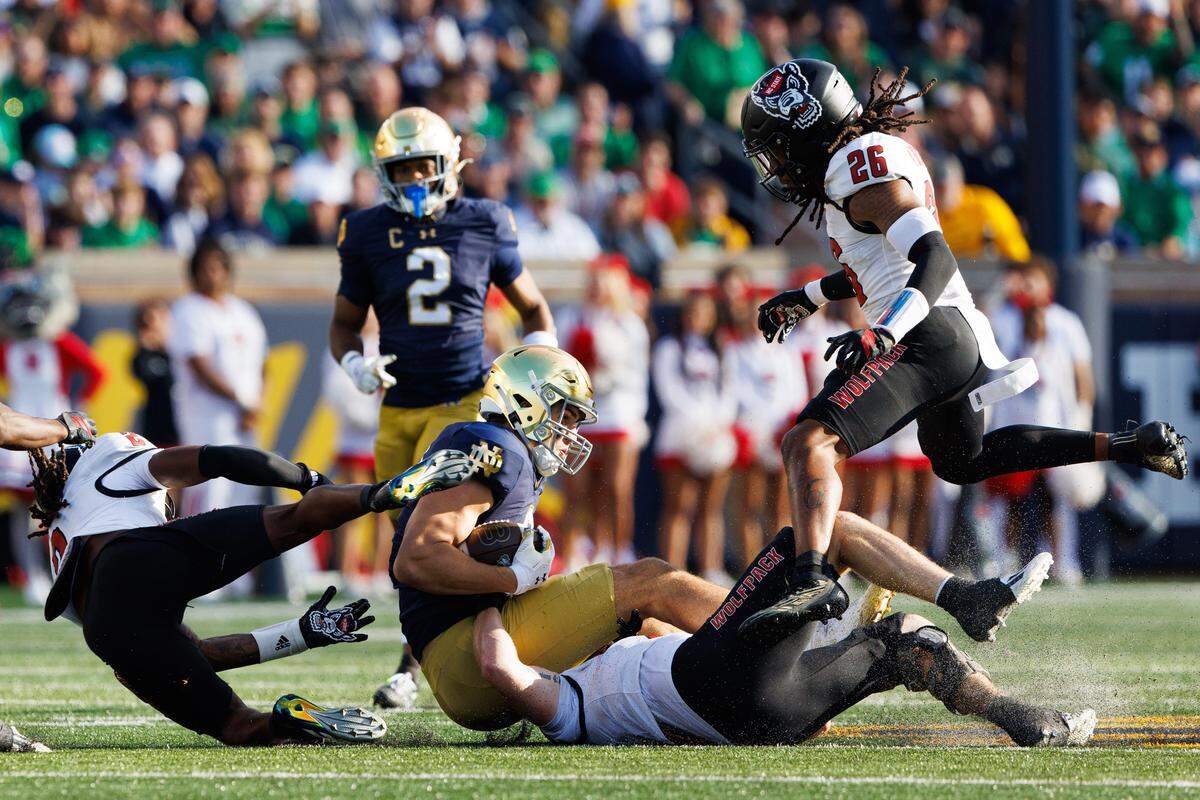 Notre Dame tight end Eli Raridon, center, is brought down in the first half of a game against NC State at Notre Dame Stadium on Saturday, Oct. 11, 2025.