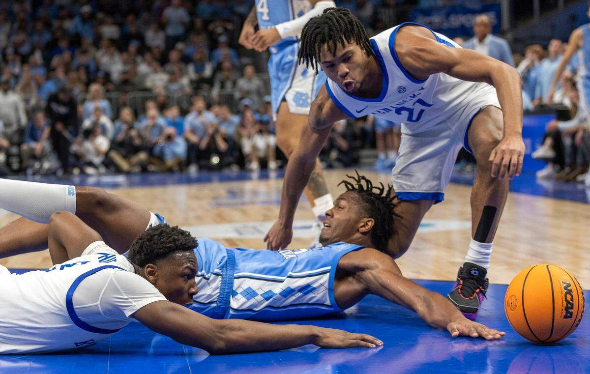 North Carolina’s Harrison Ingram (55) battles with Kentucky’s D.J. Wagner (21) and Adou Thiero (3) for a loose ball in the first half on Saturday, December 16, 2023 at State Farm Arena in Atlanta, Georgia.