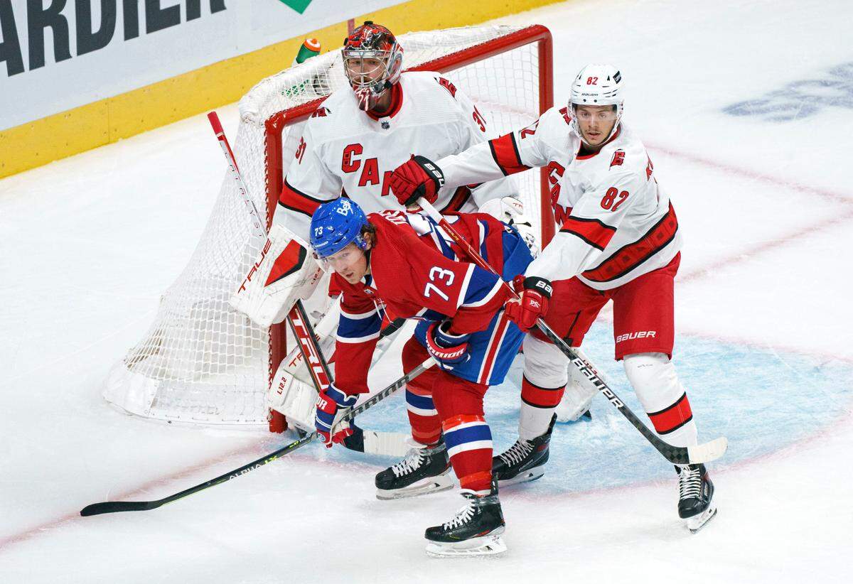 Carolina Hurricanes’ Jesperi Kotkaniemi takes out Montreal Canadiens’ Tyler Toffoli from in front of goaltender Frederik Andersen during the first period of an NHL hockey game Thursday, Oct. 21, 2021, in Montreal. (Paul Chiasson/The Canadian Press via AP)