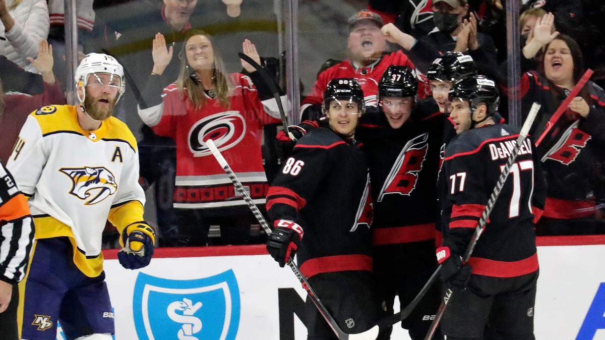 Carolina Hurricanes right wing Andrei Svechnikov (37) celebrates his goal with left wing Teuvo Teravainen (86), center Martin Necas, second from right, and defenseman Tony DeAngelo (77) while Nashville Predators defenseman Mattias Ekholm, left, skates away during the third period of an NHL hockey game Friday, Feb. 18, 2022, in Raleigh, N.C. (AP Photo/Chris Seward)