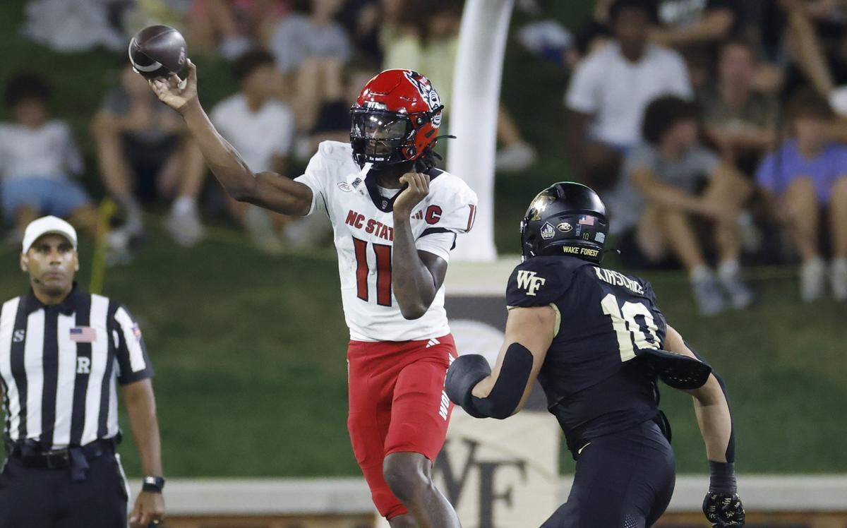 N.C. State quarterback CJ Bailey (11) throws downfield while be chased by Wake Forest’s Gabe Kirschke (10) during the first half of N.C. State’s game against Wake Forest at Allegacy Stadium in Winston-Salem, N.C., Thursday, Sept. 11, 2025.