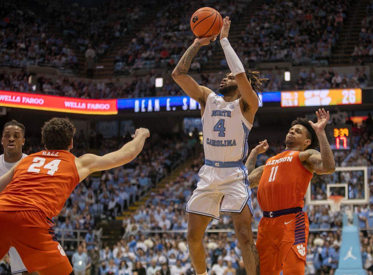 North Carolina’s R.J. Davis (4) puts up a shot between Clemson’s P.J. Hall (24) and Brevin Galloway (11) in the first half on Saturday, February 11, 2023 at the Smith Center in Chapel Hill, N.C. Davis scored 17 points.