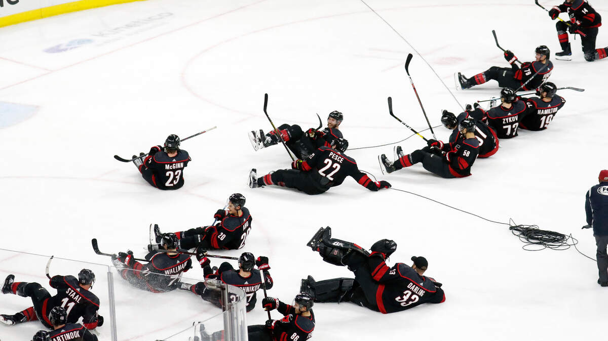 The Carolina Hurricanes’ team slides down the ice in celebration after defeating the San Jose Sharks in Raleigh, N.C. Friday, Oct. 26, 2018. 