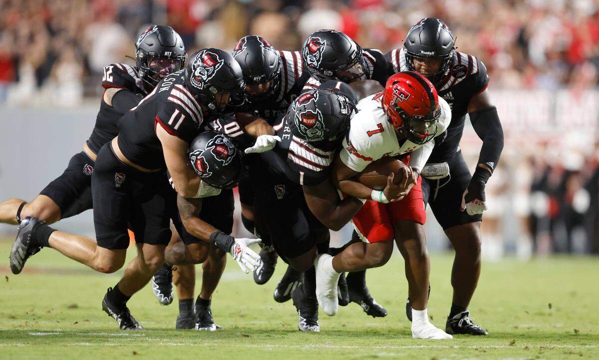 N.C. State linebacker Isaiah Moore (1) and a host of defenders stop Texas Tech quarterback Donovan Smith (7) during the first half of N.C. States game against Texas Tech at Carter-Finley Stadium in Raleigh, N.C., Saturday, Sept. 17, 2022.