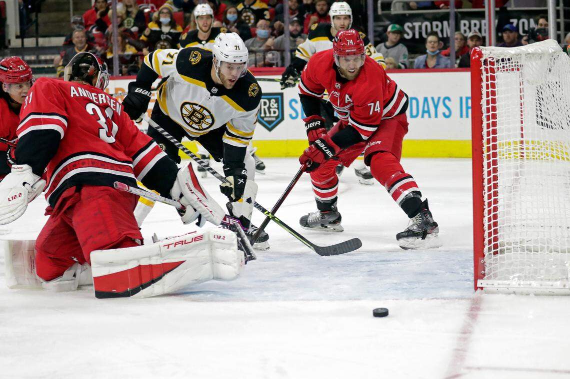 Boston Bruins left wing Taylor Hall (71) can’t get the puck in the net as he drives past Carolina Hurricanes goaltender Frederik Andersen (31) and defenseman Jaccob Slavin (74) during the third period of an NHL hockey game Thursday, Oct. 28, 2021, in Raleigh, N.C. (AP Photo/Chris Seward)
