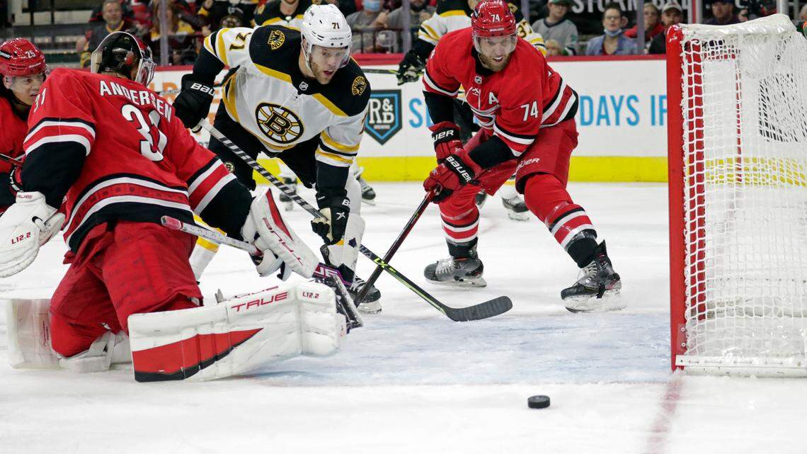 Boston Bruins left wing Taylor Hall (71) can’t get the puck in the net as he drives past Carolina Hurricanes goaltender Frederik Andersen (31) and defenseman Jaccob Slavin (74) during the third period of an NHL hockey game Thursday, Oct. 28, 2021, in Raleigh, N.C. (AP Photo/Chris Seward)