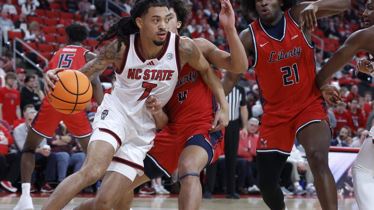 N.C. State’s Alyn Breed drives around Liberty’s Brett Decker Jr. during the second half of the Wolfpack’s 85-45 win on Wednesday, Dec. 10, 2025, at Lenovo Center in Raleigh, N.C.