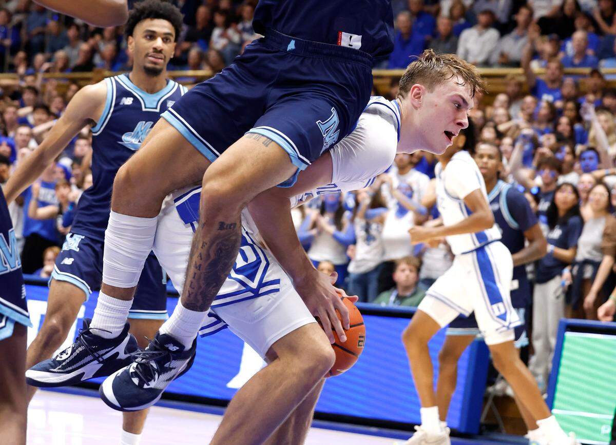 Duke’s Cooper Flagg (2) keeps the ball from Maine’s Logan Carey (0) during the first half of Duke’s game against Maine at Cameron Indoor Stadium in Durham, N.C., Monday, Nov. 4, 2024.