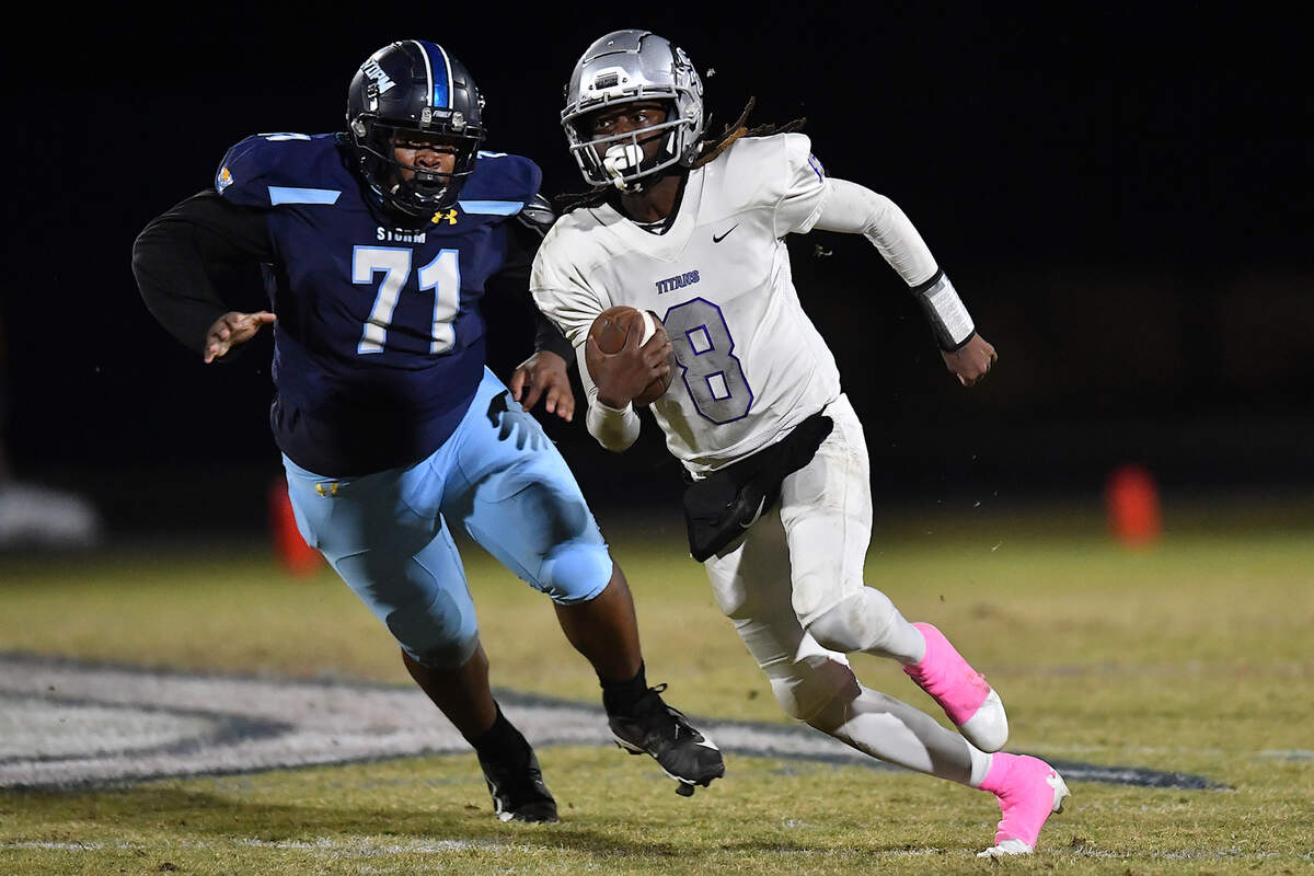 South Garner quarterback Chase Hardy (8) rushes for yardage ahead of Willow Spring’s Peyton Chisholm (71) during the first half. The Willow Spring Storm and the South Garner Titans met in a football game in Fuquay-Varina. N.C. on October 18, 2024.