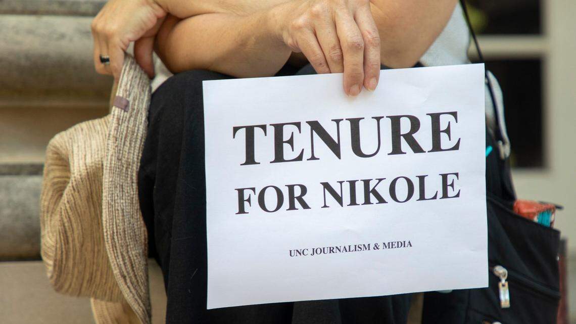 Deborah Dwyer, a doctoral candidate, holds a sign while gathered with fellow students and alumni on the steps of Carroll Hall, where the UNC-Chapel Hill Hussman School of Journalism and Media is located, before the university’s Board of Trustees is scheduled to vote on tenure for distinguished journalist Nikole Hannah-Jones, on Wednesday, Jun. 30, 2021, in Chapel Hill, N.C.