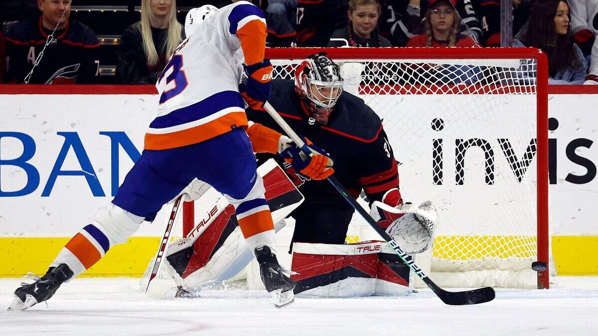 New York Islanders’ Adam Pelech (3) shoots past Carolina Hurricanes goaltender Frederik Andersen, right, during the second period of an NHL hockey game in Raleigh, N.C., Friday, Oct. 28, 2022. (AP Photo/Karl B DeBlaker)