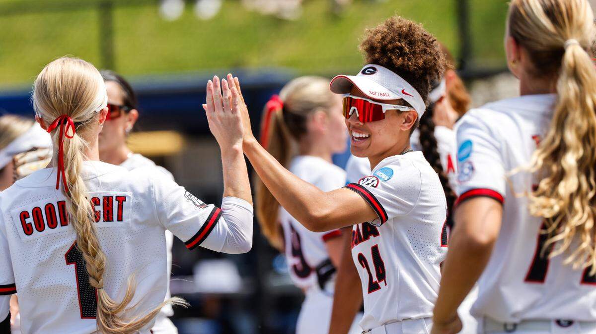 Georgia infielder Paislie Allen (24) and catcher Lyndi Rae Davis (11) high five during the Blue Devils’ regional championship game against Georgia in Durham, North Carolina, Sunday.