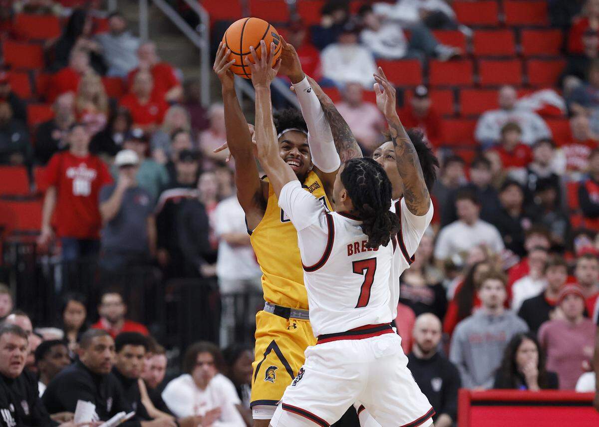 N.C. State’s Alyn Breed and Darrion Williams pressure UNC Greensboro’s Lilian Marville during the first half of the Wolfpack’s 110-64 win on Wednesday, Nov. 12, 2025, at Lenovo Center in Raleigh, N.C.