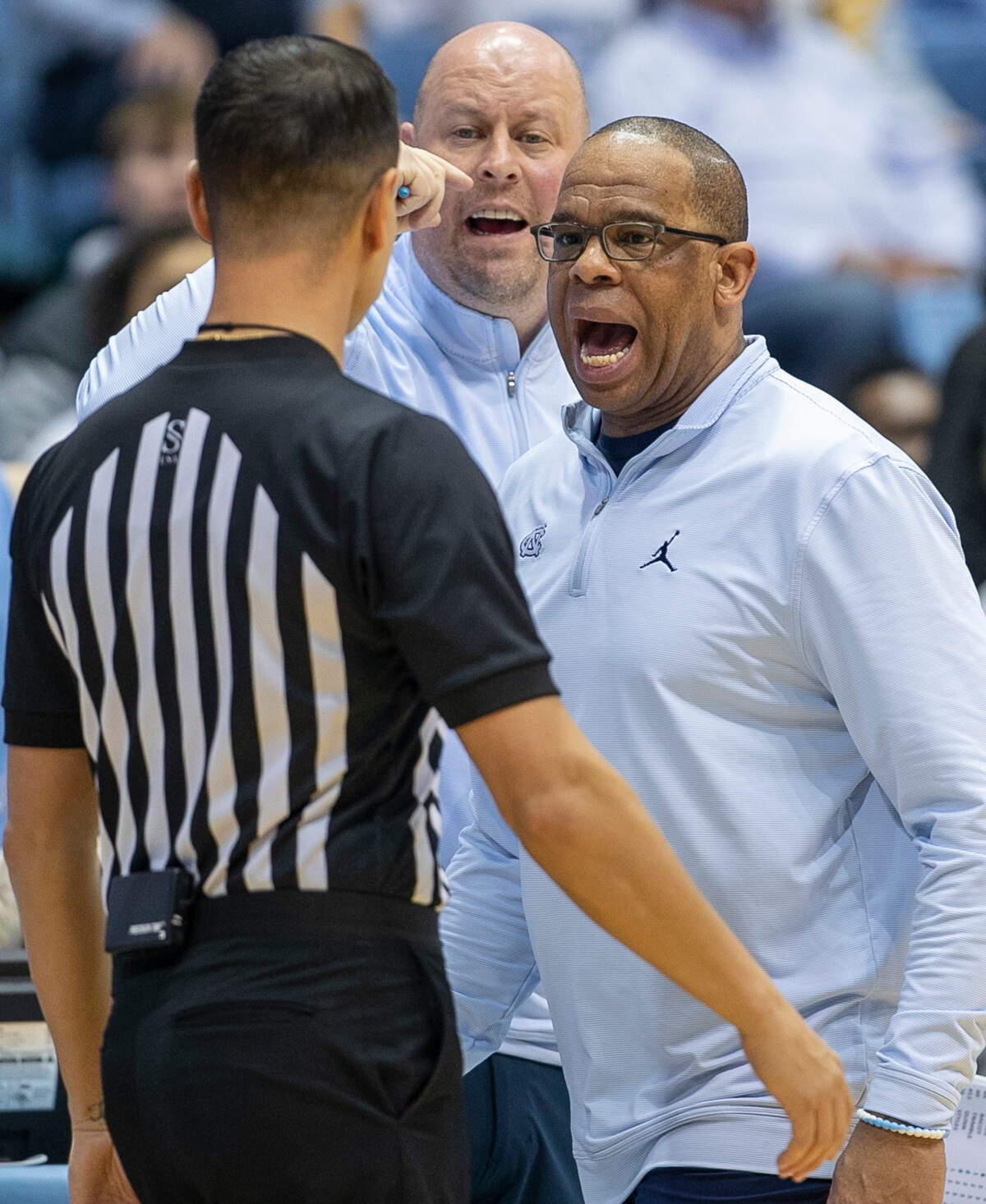 North Carolina coach Hubert Davis and assistant Pat Sullivan have a word with official A.J. Desai in the second half against Notre Dame on Saturday, January 7, 2023 at the Smith Center in Chapel Hill, N.C.