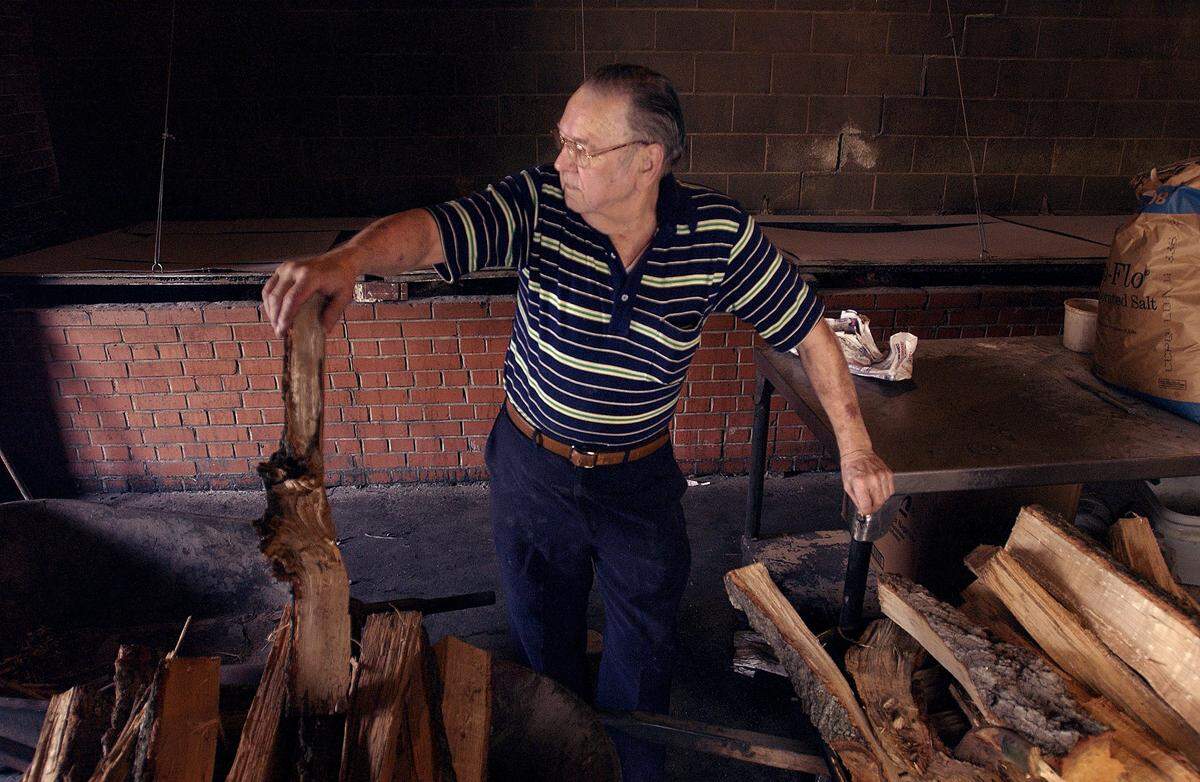 Barbecue legend Pete Jones in the cook house of the Skylight Inn in 2003. Jones started cooking whole hog barbecue in 1947 and cooked pigs for 15 hours under glowing hickory and oak coals. “It’s not barbecue if it’s not cooked over wood.” he said. When Jones was growing up, he was given the choice of working in the fields or in the kitchen.