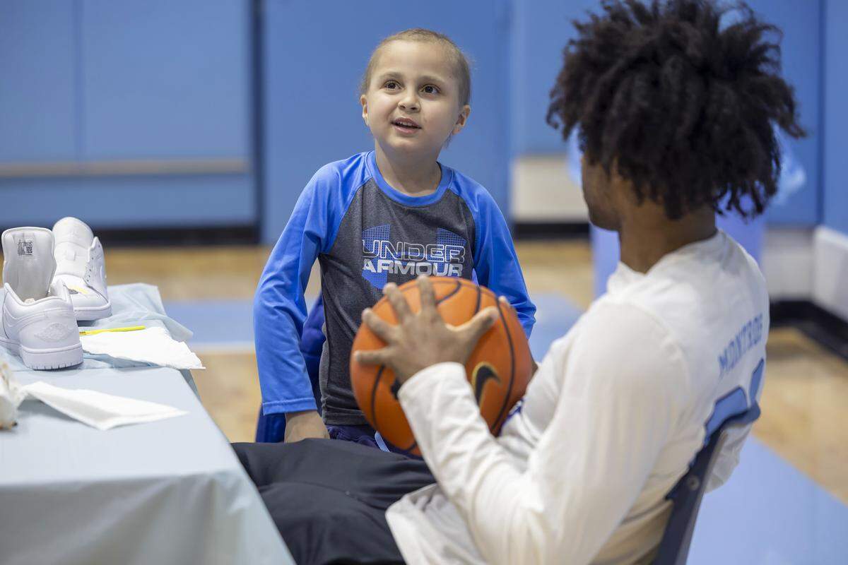 Seven-year-old Jude Rifkin talks with North Carolina guard Evan Smith during a Shoes 4 Hope event on  Dec. 14 at the Smith Center in Chapel Hill, N.C.