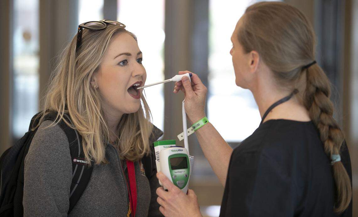 Bridget Chapman a reporter with CBS-17 has her temperature taken prior to entering the Wake County Justice Center for a press conference on the COVID-19 virus with Wake County government agencies on Sunday, March 22, 2020, in Raleigh, N.C.