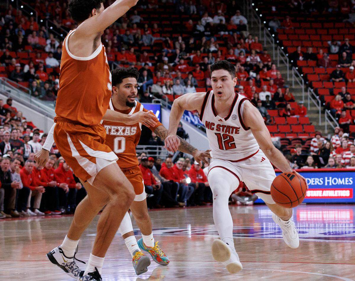 N.C. State’s Michael O’Connell pushes the ball past Texas’ Jordan Pope during the second half of the Wolfpack’s 63-59 loss on Wednesday, Dec. 4, 2024, at Lenovo Center in Raleigh, N.C.
