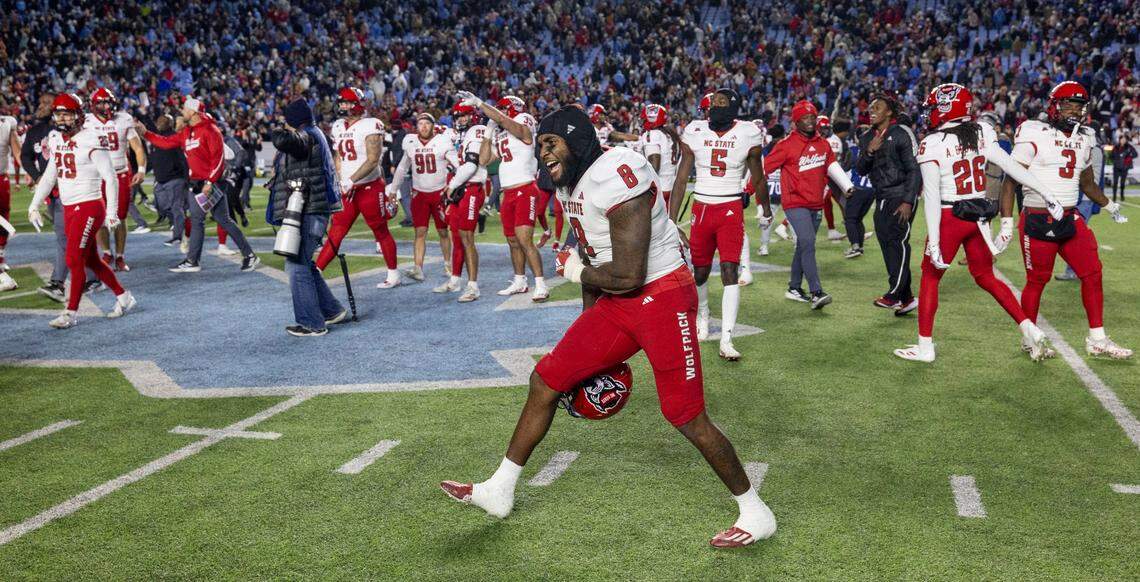 N.C. State linebacker Devon Betty (8) and his teammates celebrate the Wolfpack’s 35-30 victory over North Carolina on Saturday, November 30, 2024 at Kenan Stadium in Chapel Hill, N.C.