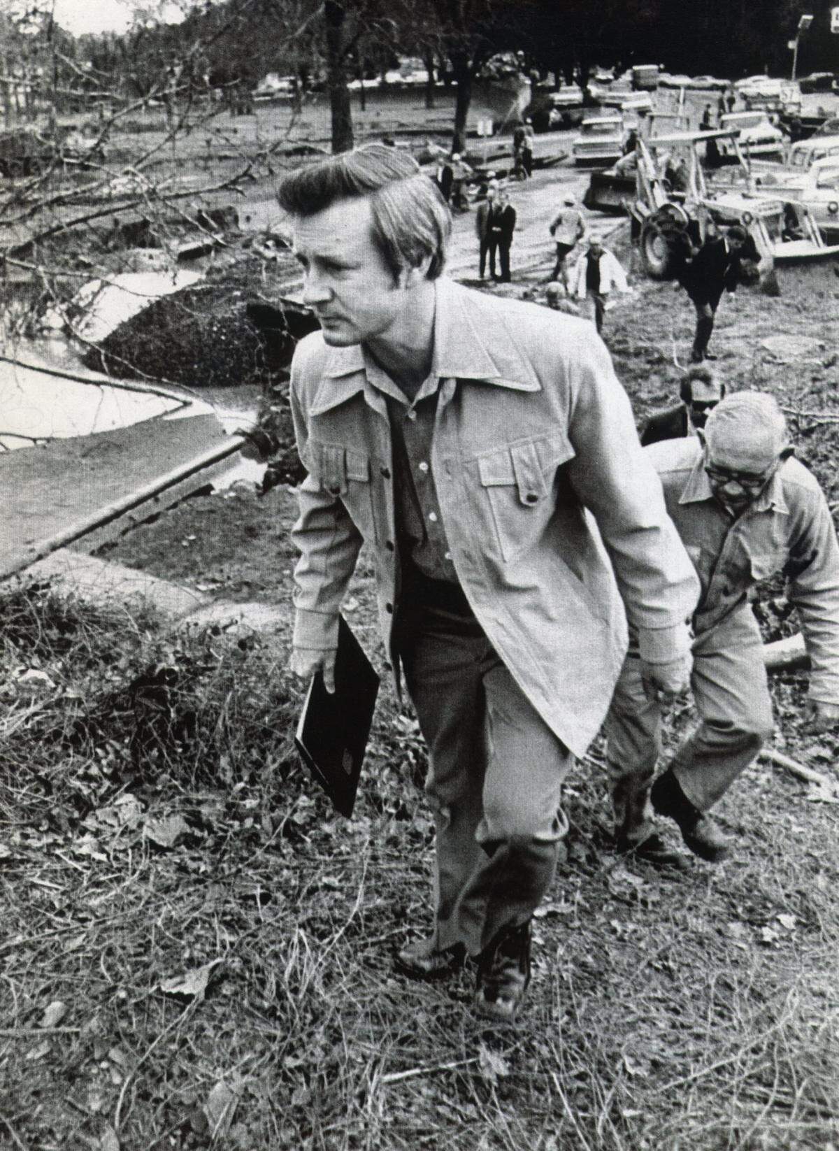 Gov. Jim Hunt walks up a bank at the American Enka textile plant near Asheville, getting a first hand look at the damage done by floods that killed 10 persons in November 1977.