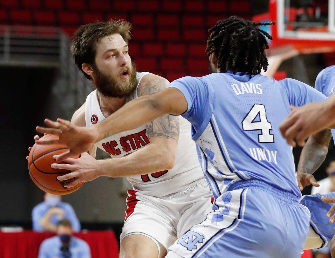 N.C. State’s Braxton Beverly (10) looks for room to pass around the pressure by North Carolina’s R.J. Davis (4) during the second half of N.C. State’s 79-76 victory over UNC at PNC Arena in Raleigh, N.C., Tuesday, December 22, 2020.