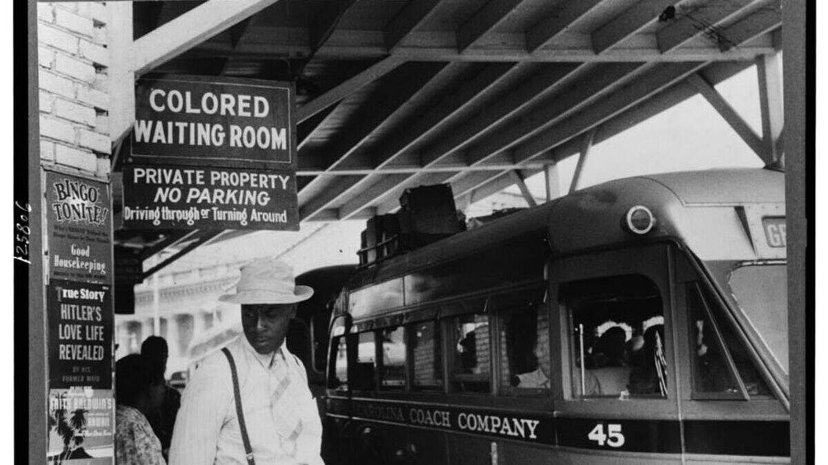 This Library of Congress photo shows the Durham, NC bus station in May 1940 when states like North Carolina enforced segregation through Jim Crow laws that forced Black people to use separate restrooms, separate waiting rooms and ride at the back of bus.