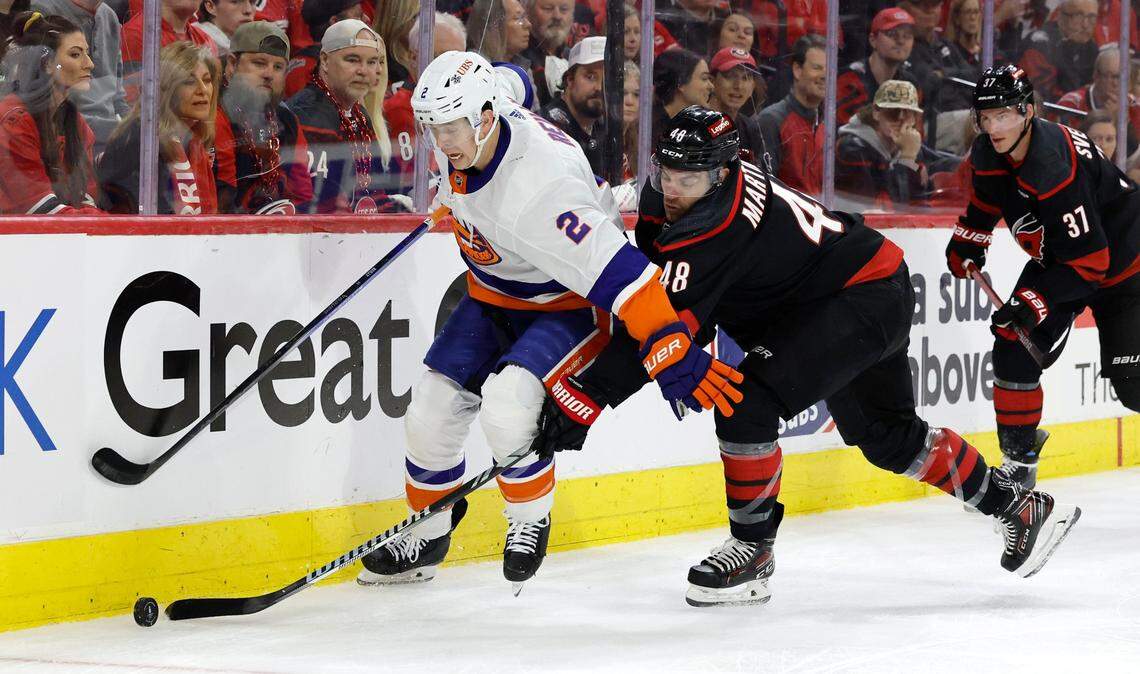 Carolina left wing Jordan Martinook (48) tries to steal the puck from New York defenseman Mike Reilly (2) during the first period of the Hurricanes game against the Islanders in the first round of the Stanley Cup playoffs at PNC Arena in Raleigh, N.C., Saturday, April 20, 2024.