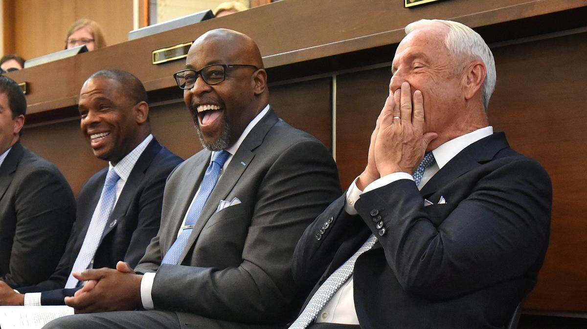 UNC head basketball coach Roy Williams (right) covers his face and laughs with assistant coaches Hubert Davis (left) and Steve Robinson during a joint session of the N.C. House and Senate at the N.C. Legislative building in Raleigh, N.C. Wednesday, May 3 , 2017. Rep. David Lewis, of Harnett County, introduced a resolution for Theo Pinson and Justin Jackson to remain on the Tar Heels’ team to facilitate winning the National Championship in 2018.